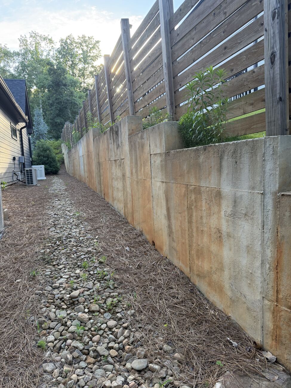 Retaining wall before cleaning — heavy orange staining